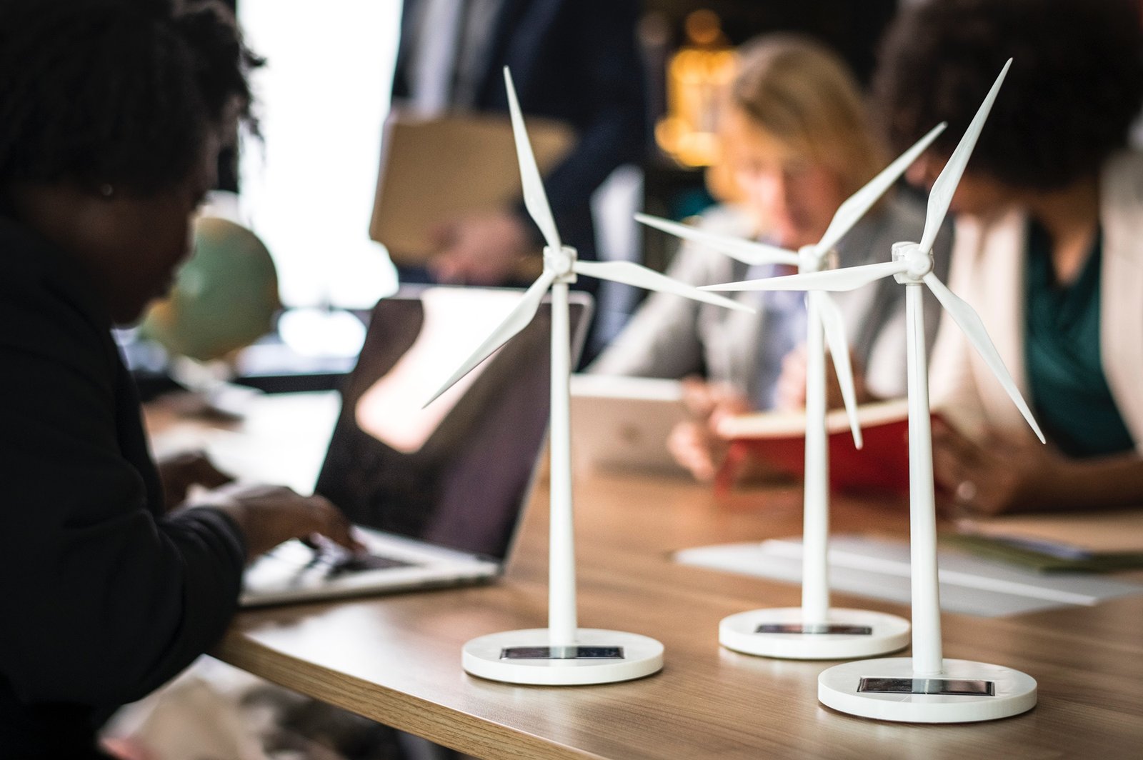 Un groupe de personnes assises autour d'une table empreinte avec des éoliennes.