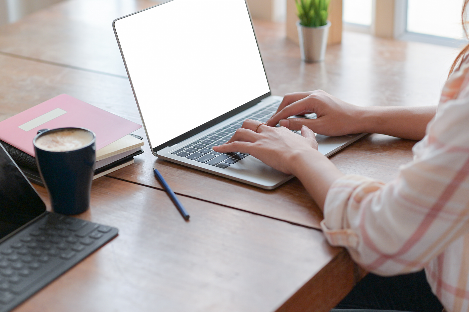 Une femme tapant sur un ordinateur portable à un bureau tout en utilisant Convertio.co.